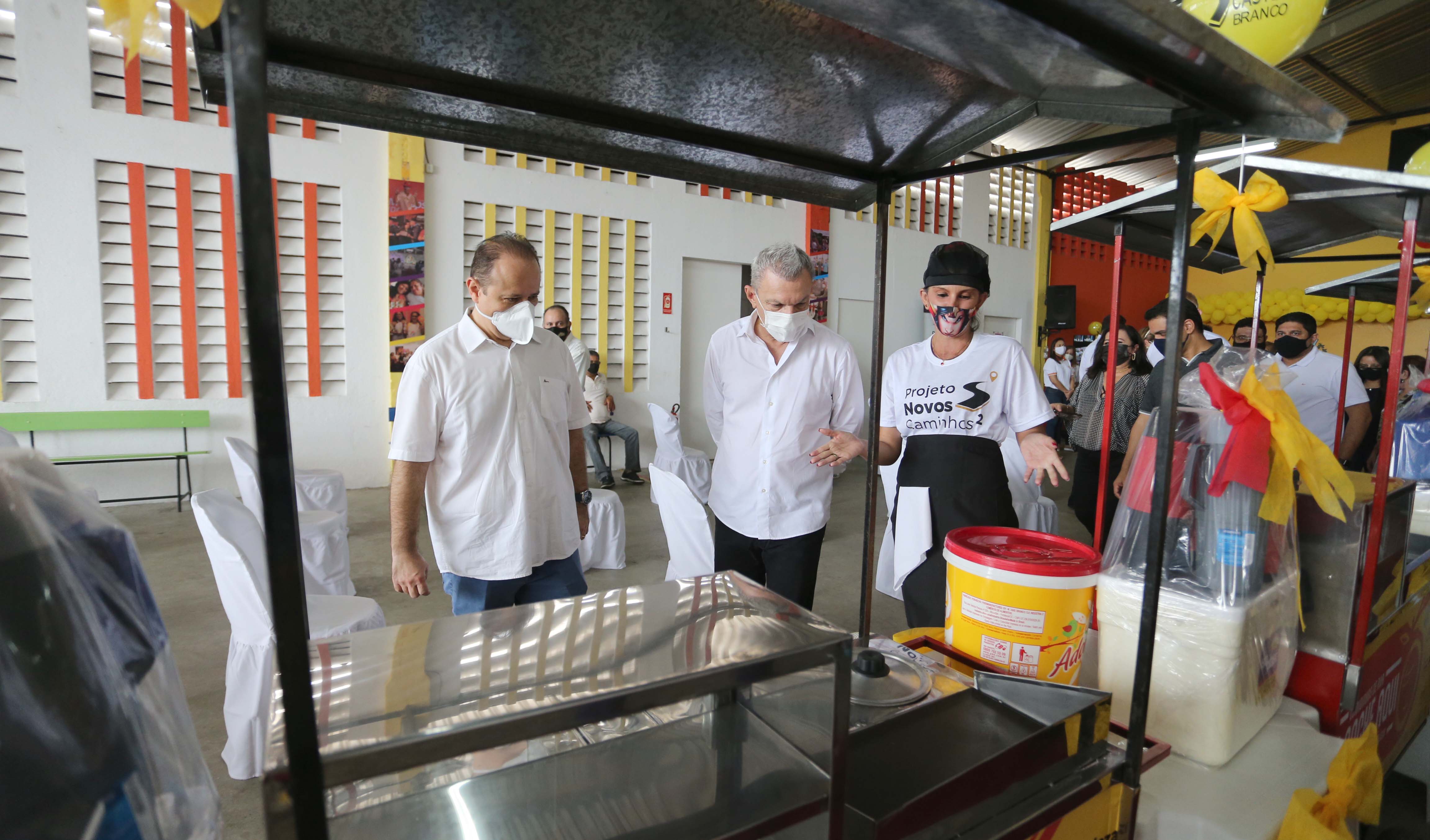 prefeito olha para um dos carrinhos de lanche entregues